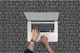 Aufsicht auf Laptop vor Binärcode